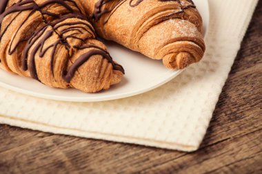 ahşap rustik zemin üzerine taze kruvasanlar plakalı  