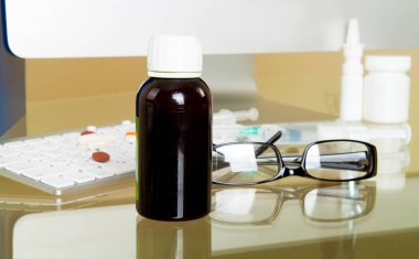 Doktor çalışma alanı ile hapları ve gözlük ile klavye ve hastanın geçmiş veritabanı