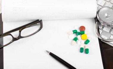 Doktor çalışma alanı hapları ve boş beyaz kağıt kalem ile 