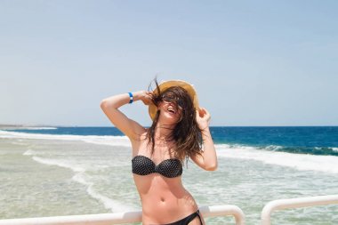 Deniz kenarındaki iskelede esmer kadın.