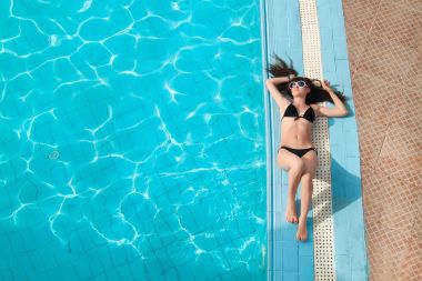 güzel ve genç birbayan rahatlatıcı yüzme havuzunda. Yukarıdan görüntülemek