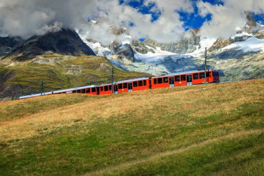 Electric tourist train with high mountains,Switzerland,Europe clipart