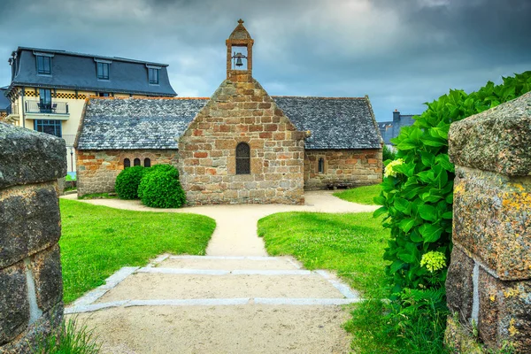 Antigua iglesia de piedra con entrada florida en la región de Bretaña, Francia — Foto de Stock