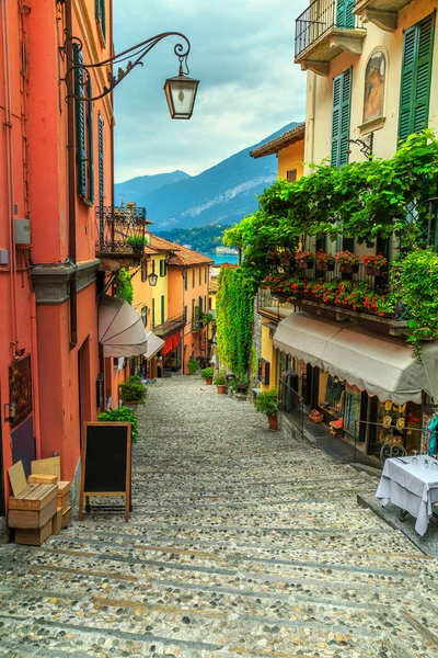 Splendida strada panoramica con case colorate e fiori a Bellagio — Foto Stock