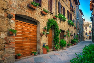 Pienza, Toskana, İtalya 'da çiçeklerle süslenmiş şirin dar bir cadde.