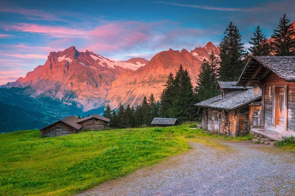 Wspaniałe położenie alpejskie lato z drewnianymi domkami i górami, Szwajcaria — Zdjęcie stockowe