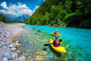Slovenya 'nın Bovec kentinde turkuaz Soca nehrinde sportif kayakçılar