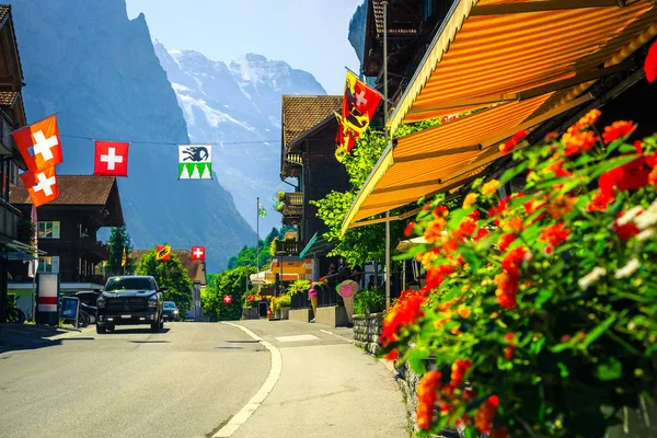 Piękna ulica z kwiatowymi dekoracjami w Lauterbrunnen górskiej miejscowości, Szwajcaria — Zdjęcie stockowe