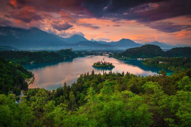 Bled 'deki küçük ada, kilise ve şatosuyla harika bir akşam manzarası. Fantastik seyahat ve turistik konum, göl arka planda küçük ada ve Karavanke dağları, Slovenya, Avrupa