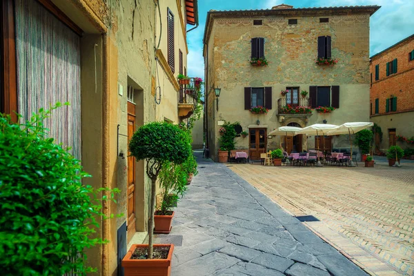 Pienza, Toskana, İtalya, Avrupa 'da eski asfalt sokakta masa ve sandalyeli şirin bir sokak kahvesi.