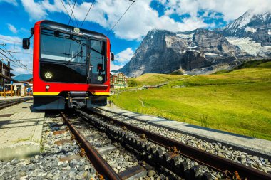 Popüler çarkıfelek kırmızı treni dağ tren istasyonuna park etti. Kleine Scheidegg dağ istasyonundaki turistik tren, Grindelwald, Bernese Oberland, İsviçre, Avrupa