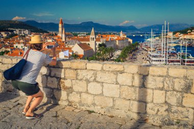Şatodan telefonla fotoğraf çeken güzel bir kadın. Akıllı telefonlu mutlu gezgin kadın, Trogir 'in eski kasabasında Kamerlenko kalesi, Dalmaçya, Hırvatistan ve Avrupa' dan seyahat görüntüleri çekiyor. 