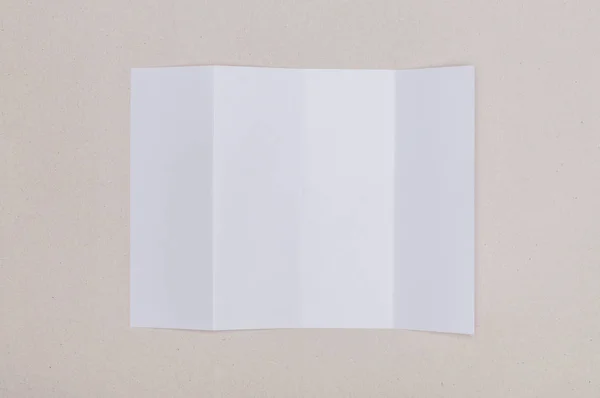 Four fold white template paper on grey background — Stock Photo, Image