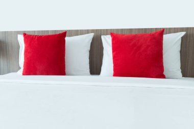 Kırmızı ve beyaz yastıklar bir yatakta