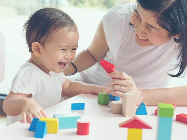 Asiatique maman et fille enfant jouer avec des blocs. Effets vintage et — Photo