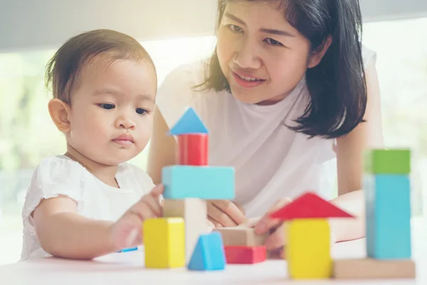 Asiatique maman et fille enfant jouer avec des blocs. Effets vintage et — Photo