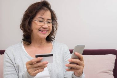 Mutlu Asyalı üst düzey kadın online ödeme kredi kartı ile alışveriş