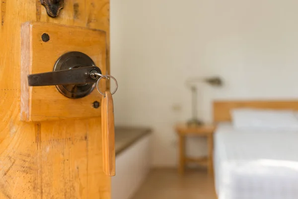 Half opened door of a bed room, key in keyhole — Stock Photo, Image