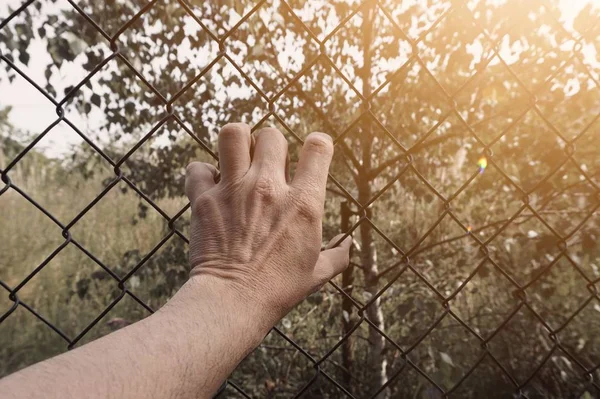 Άνθρωπος Χέρι Αρπάζοντας Ένα Μεταλλικό Φράχτη Στο Δρόμο — Φωτογραφία Αρχείου