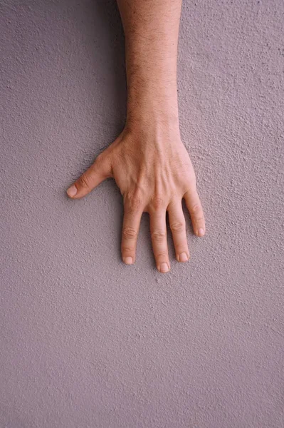 man hand gesturing on the pink wall, pink background