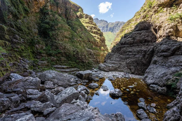 Hiking trail in the Jonkershoek nature reserve into a hidden waterfall, with water and rocks