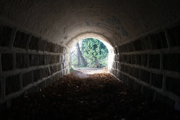 Tunnel con luce alla fine, c'è speranza alla fine, tunnel muro di pietra. buio all'inizio — Foto Stock
