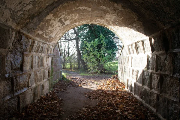 Tunnel met licht aan het eind, er is hoop aan het einde, stenen muurtunnel. donker in het begin Stockfoto