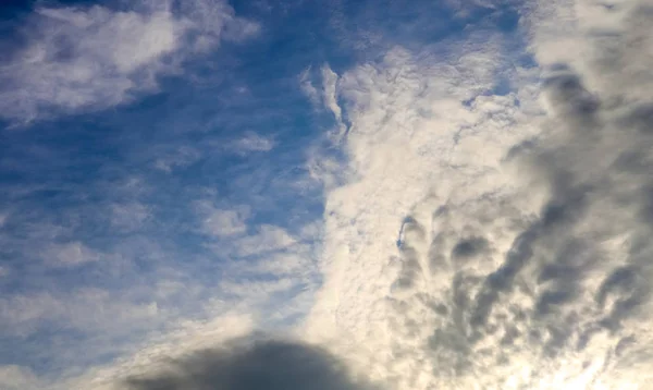 在深蓝色的夏日天空中飘扬着飘扬的白云 — 图库照片