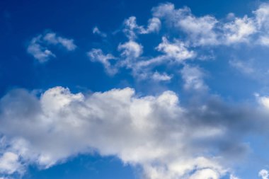 Koyu mavi bir gökyüzünde güzel, tüylü bulut oluşumları