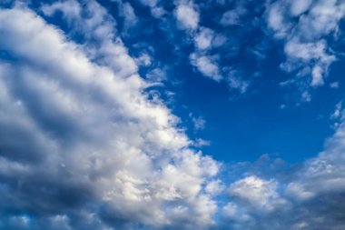 Güzel beyaz tüylü kümülüs ve masmavi gökyüzünde sirrus bulutları.