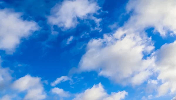 Beautiful view on white fluffy clouds in a deep blue sky