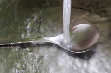Running water out of a water tap in a metallic kitchen sink  clipart