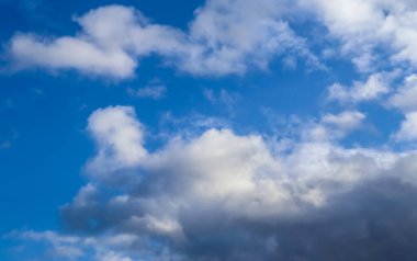 Güzel, beyaz, tüylü kümülüs bulutları. Derin mavi bir yaz gökyüzünde.