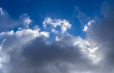 Güneşli bir yaz gününde mavi gökyüzünde güzel, tüylü bulutlar.