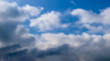 Koyu mavi bir yaz gökyüzünde güzel, tüylü bulutlar.