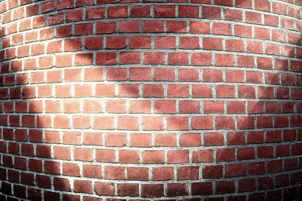 Detailed close up view at a red brick wall with multiple spotlights on it