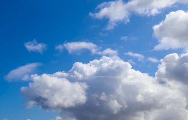 Koyu mavi bir yaz gökyüzünde güzel, tüylü bulutlar.