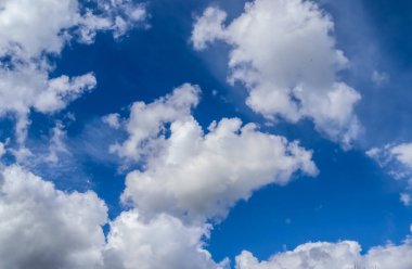 Koyu mavi bir yaz gökyüzünde güzel, tüylü bulutlar.