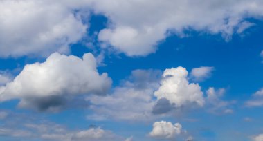 Koyu mavi bir yaz gökyüzünde güzel, tüylü bulutlar.