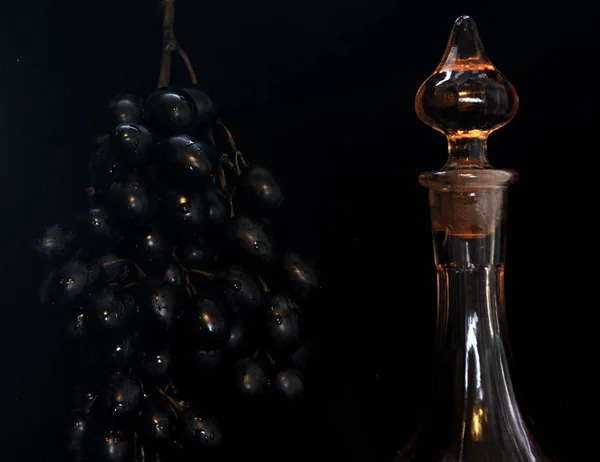 Тёмном Фоне Куча Чёрного Винограда Рядом Графином Вина Концепция Виноделия — стоковое фото