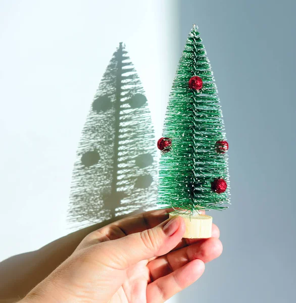 Una Mano Femminile Albero Natale Giocattolo Uno Sfondo Bianco Ombra — Foto Stock