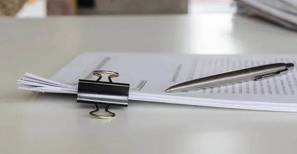 Tafel Liggen Papieren Met Een Clip Vlakbij Een Zilveren Pen — Stockfoto