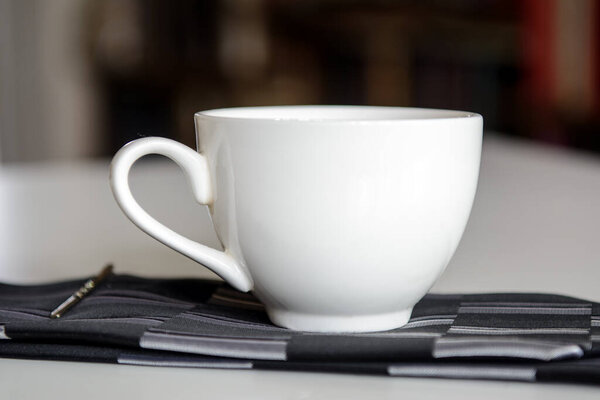 Кофейная чашка стоит на галстуке. Концепция - бизнес-завтрак, проснуться утром, утренний кофе
