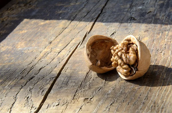 stock image Walnut and half shell on a wooden board. The concept is to open your mind, to be open to the world.