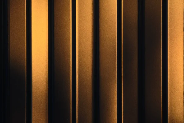 A metal fence made of profiled sheet is lit by the evening sun. Golden light. Evening lighting. Kocnept - background