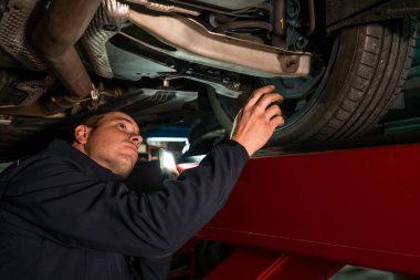 Tamirci mekanik atölyesinde çalışıyor. Frenler ve süspansiyonlar kontrol ediliyor.