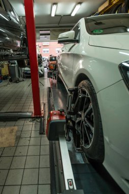 Tamirci mekanik atölyesinde çalışıyor. Paralel tekerlekler kontrol ediliyor.