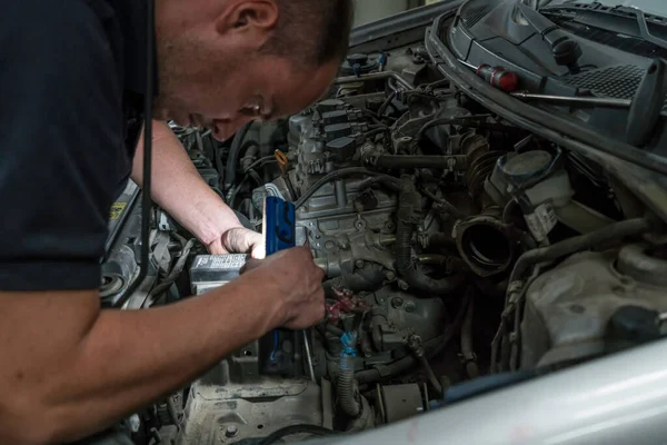 Mecánico de automóviles trabajando en el motor del coche en el garaje mecánico. Servicio de reparación de coches . — Foto de Stock