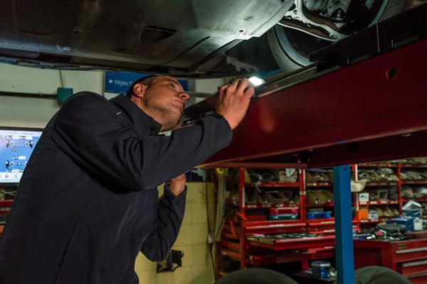 Mécanicien automobile travaillant dans un atelier mécanique. Contrôle des freins et suspensions — Photo