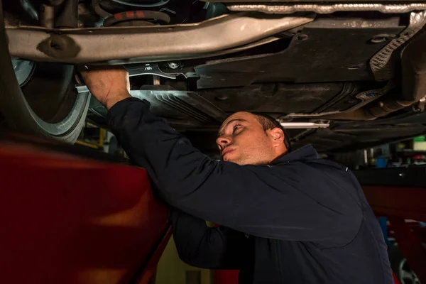 Mécanicien automobile travaillant dans un atelier mécanique. Contrôle des freins et suspensions — Photo